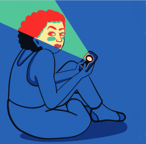Let's talk about stalking and situationships too A woman with curly hair sitting cross legged on the floor looking at her cell phone, which is looking back at her with a spotlight.